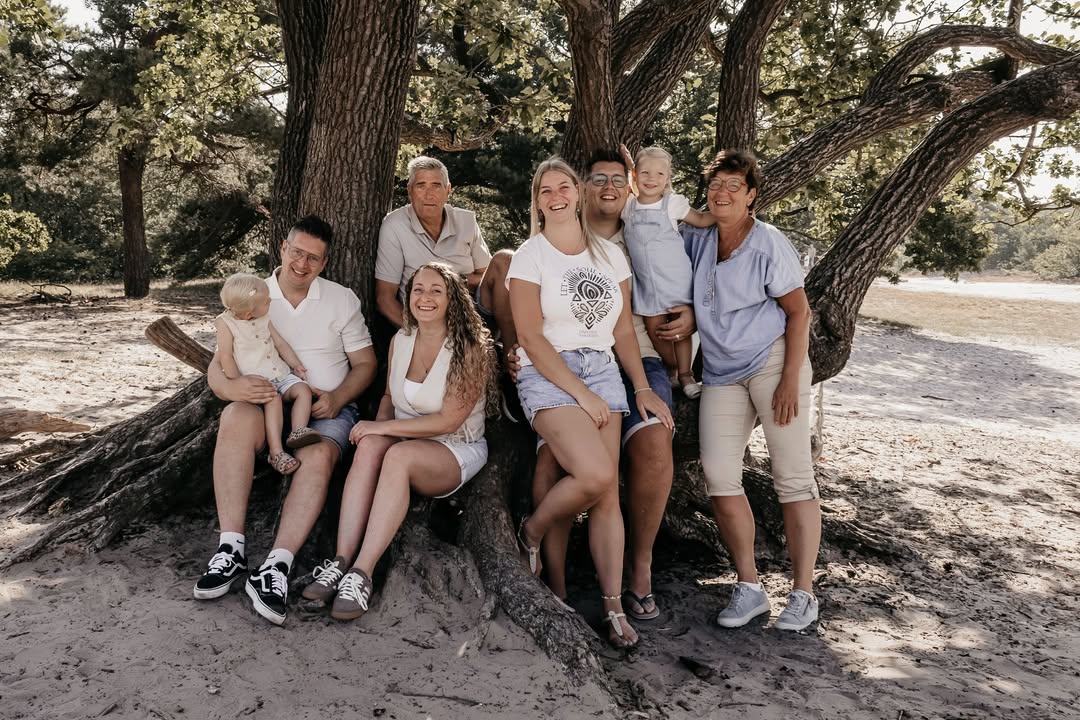 Familie van drie generaties onder een grote boom
