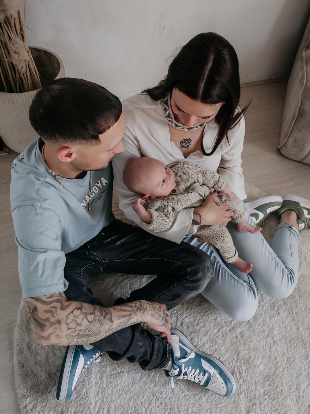 Ouders zitten op de grond met hun pasgeboren baby