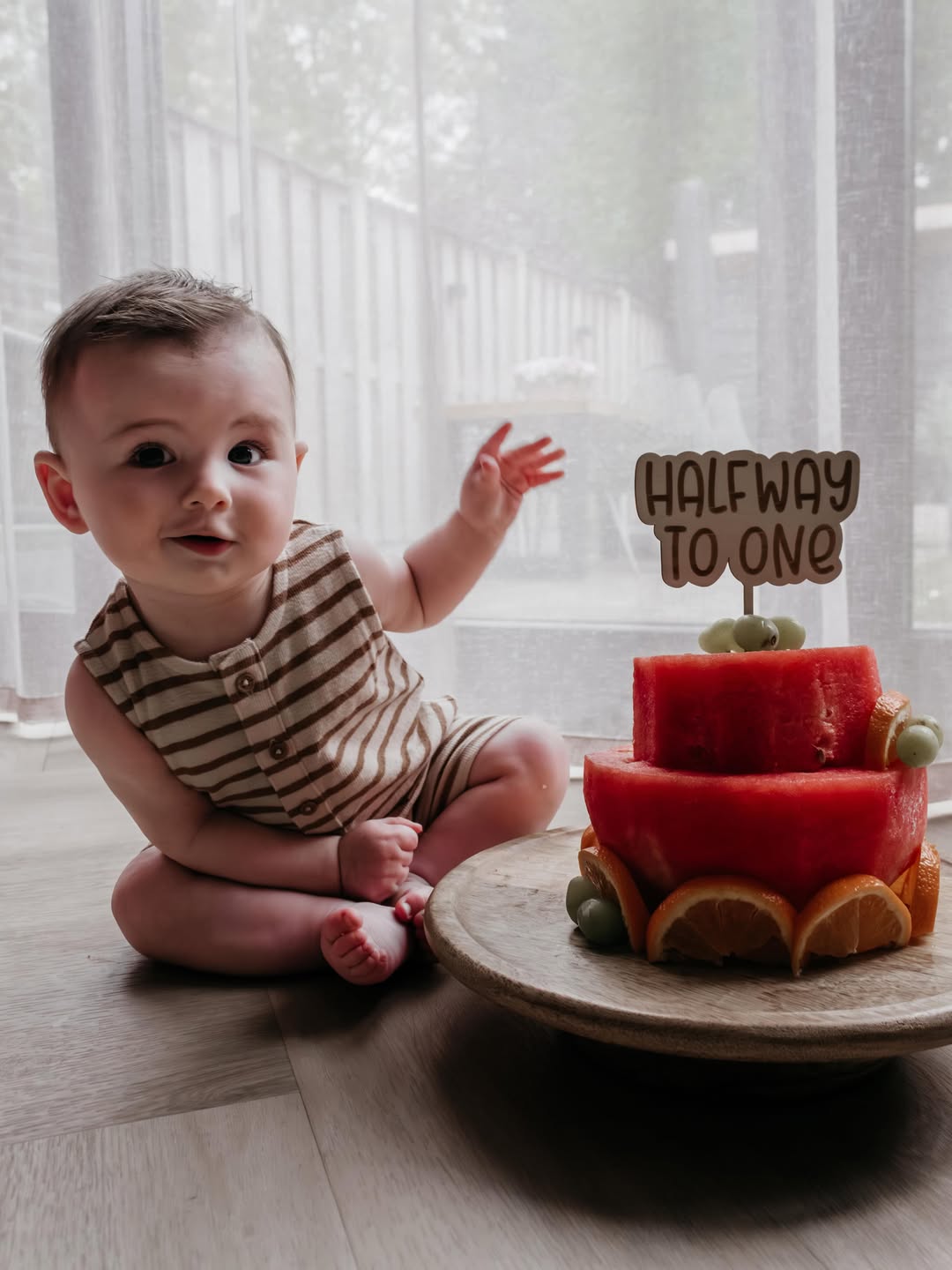 Baby van een half jaar naast een taart van watermeloen