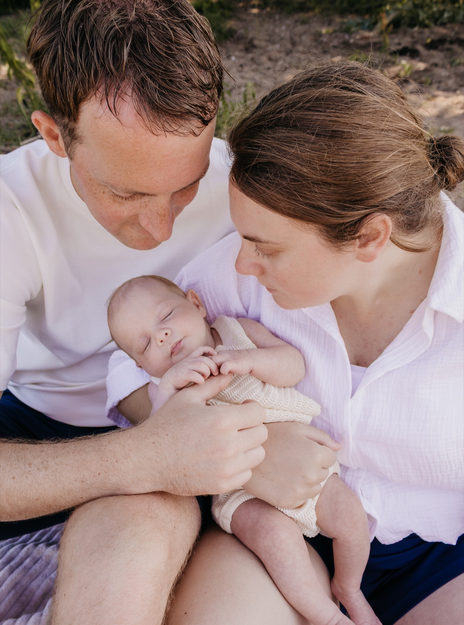 Ouders kijken naar hun slapende baby in de tuin