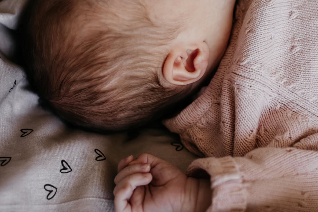 Close-up van het oortje en handje van een pasgeboren baby