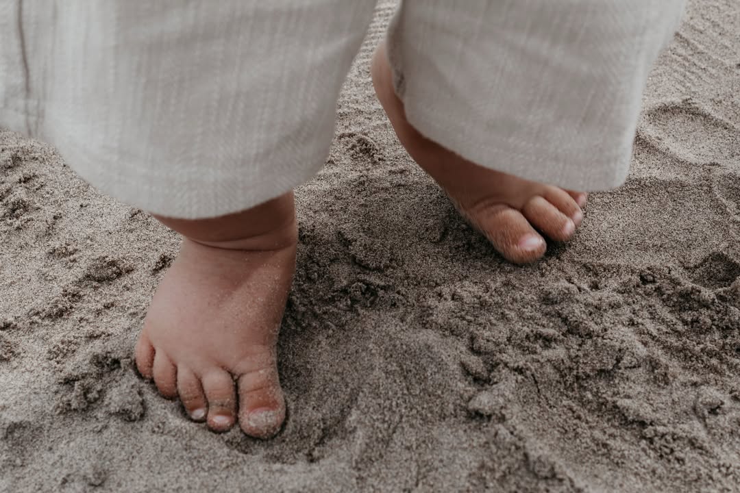 Blote kindervoetjes in het zand